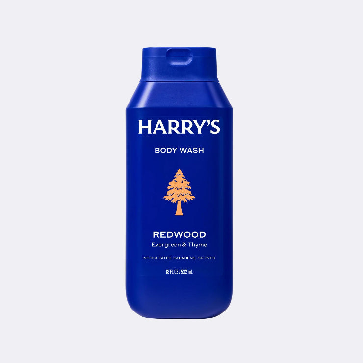 Blue bottle of Harry's body wash with a tree logo on a light gray background
